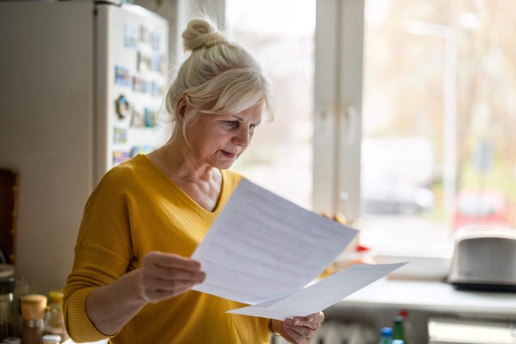 Woman reading documents in kitchen.