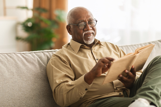 Man reading a book on sofa.